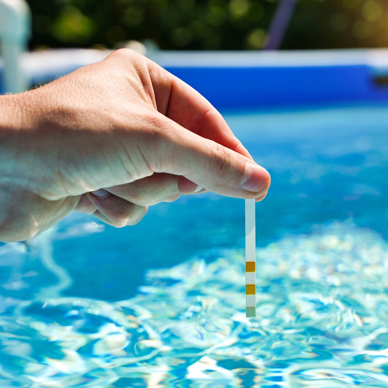 hand testing water from swimming pool